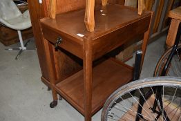 A teak tea trolley having integral drawer