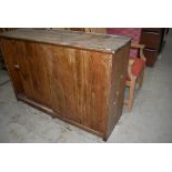 A rustic pine side cabinet having sliding doors