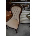A reproduction nursing chair having button back with mahogany frame