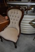 A reproduction nursing chair having button back with mahogany frame