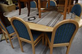 A modern Ash oval dining table and 6 chairs having upholstered seats and backs