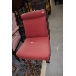 A low nursing or bedroom chair having oak frame with red upholstery