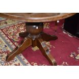 A modern oak circular dining table having bulbous column and chunky legs