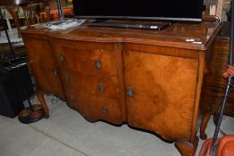 An antique side board in a burr veneer having double cupboard and three drawer