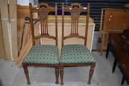 A pair of early 20th Century oak dining chairs having overstuffed seats