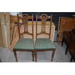 A pair of early 20th Century oak dining chairs having overstuffed seats