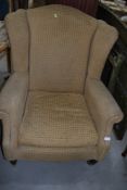 A reproduction wing back armchair