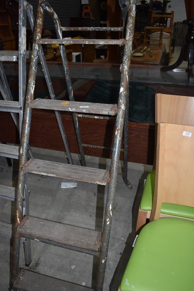 A set of fold away metal framed wooden step ladders
