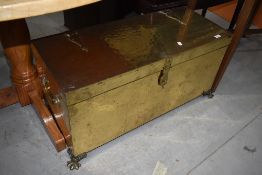 An early 20th Century brass casket in the Arts and Crafts style with claw feet and ply lining