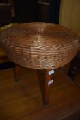 A vintage wickerwork stool on three dansette style legs