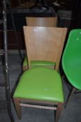 A pair of beech and ply kitchen dining chairs, having lime green vinyl seats, labelled Pineapple