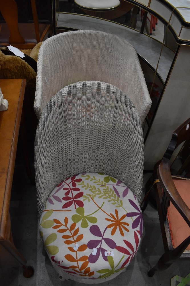 Two woven fibre tub chairs one in a nursing design and similar arm chair styled one labeled Lloyd