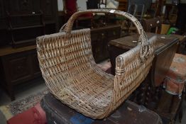 A wicker woven log basket or open ended flower trug