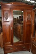 A traditional wardrobe having carved panel doors with under drawer