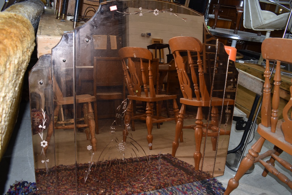 A vintage peach glass mirror with etched 'crinoline lady' decoration