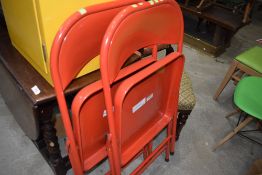 A pair of red metal fold away chairs retailed by Habitat