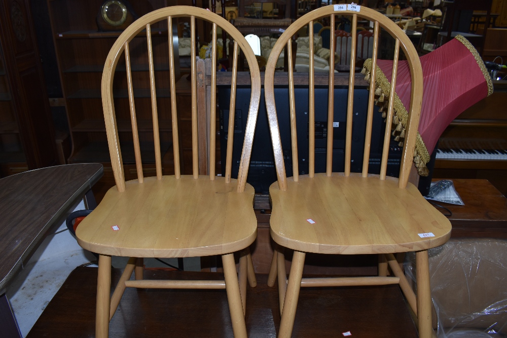 Two light stained hoop back dining chairs