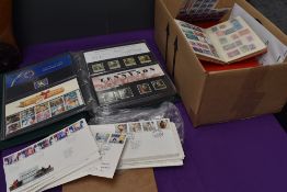 A box containing GB First Day Covers, an Album of Presentation Packs and five Albums of World Stamps