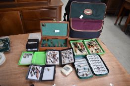 A selection of salmon and trout flies in plastic and metal fly boxes with a canvas bag.