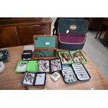 A selection of salmon and trout flies in plastic and metal fly boxes with a canvas bag.