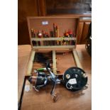 Fishing float box and contents with giant spinning reel and paramount fly reel.