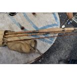 A vintage cane fishing rod approx 11ft unmarked with sleeve