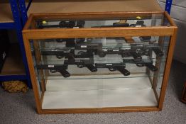 A wood and glass display case having three glass shelves