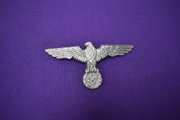 A German WW2 Cap Badge, eagle facing left gripping wreath containing swastika, length 11cm