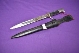 A WW2 German Dress Bayonet 1939-45 with single quillion crossguard, leather frog, metal scabbard,