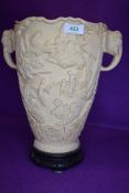 A reproduction ivory style twin handle vase having elephant motif and landscape relief