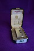 A cigarette smokers pocket lighter by Dunhill having machine tooled case and original box