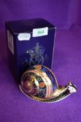 A ceramic Royal Crown Derby paper weight or figure of a Garden Snail having gold stopper and box