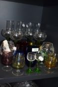 A selection of various colour and clear cut wine and spirit glasses including green stem champagne
