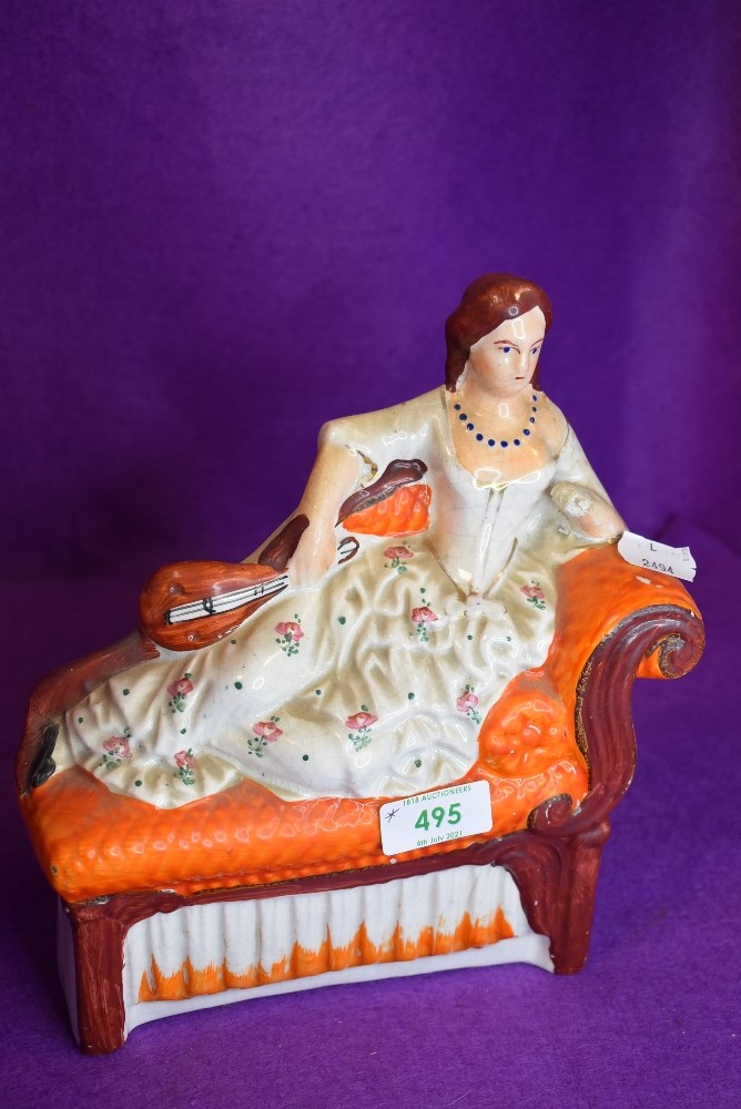 An antique Staffordshire flat back depicting reclined lady with mandolin.