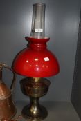 A red glass top shade oil burning lamp with chimney