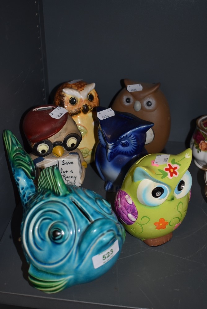 A selection of owl style money boxes and a similar fish one