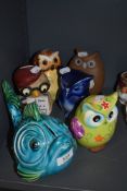 A selection of owl style money boxes and a similar fish one