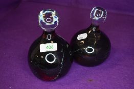 Two art glass droplet handle paper weights having dark green and burgundy centre swirls