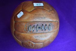 A vintage leather bound and stitched football by Mark Cross