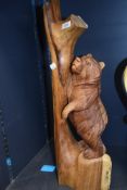 A hand carved bear and branch figure in a Black Forrest style