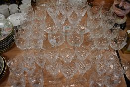 A selection of clear cut crystal glass ware including wine whisky port and champagne glasses