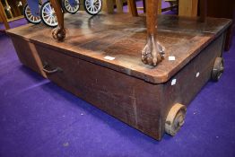 A vintage underbed or similar bedding box, having wooden wheels