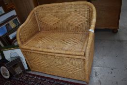 A wicker woven fibre storage seat with bamboo frame work