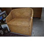 A wicker woven fibre storage seat with bamboo frame work