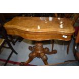 A fold out card table possibly late Victorian having carved base with Burr veneer decorated top