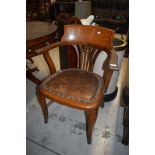 An Edwardian captains or office arm chair having oak frame with leather button seat