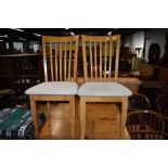 A set of four modern rubberwood dining chairs having upholstered seats