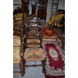 Three 19th Century oak ladder back chairs having rush seats