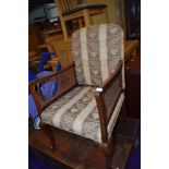 An early 20th Century easy chair having bergere sides and ball and claw feet