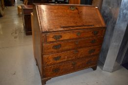 A 19th Century oak bureau, having four long drawers and bracket feet